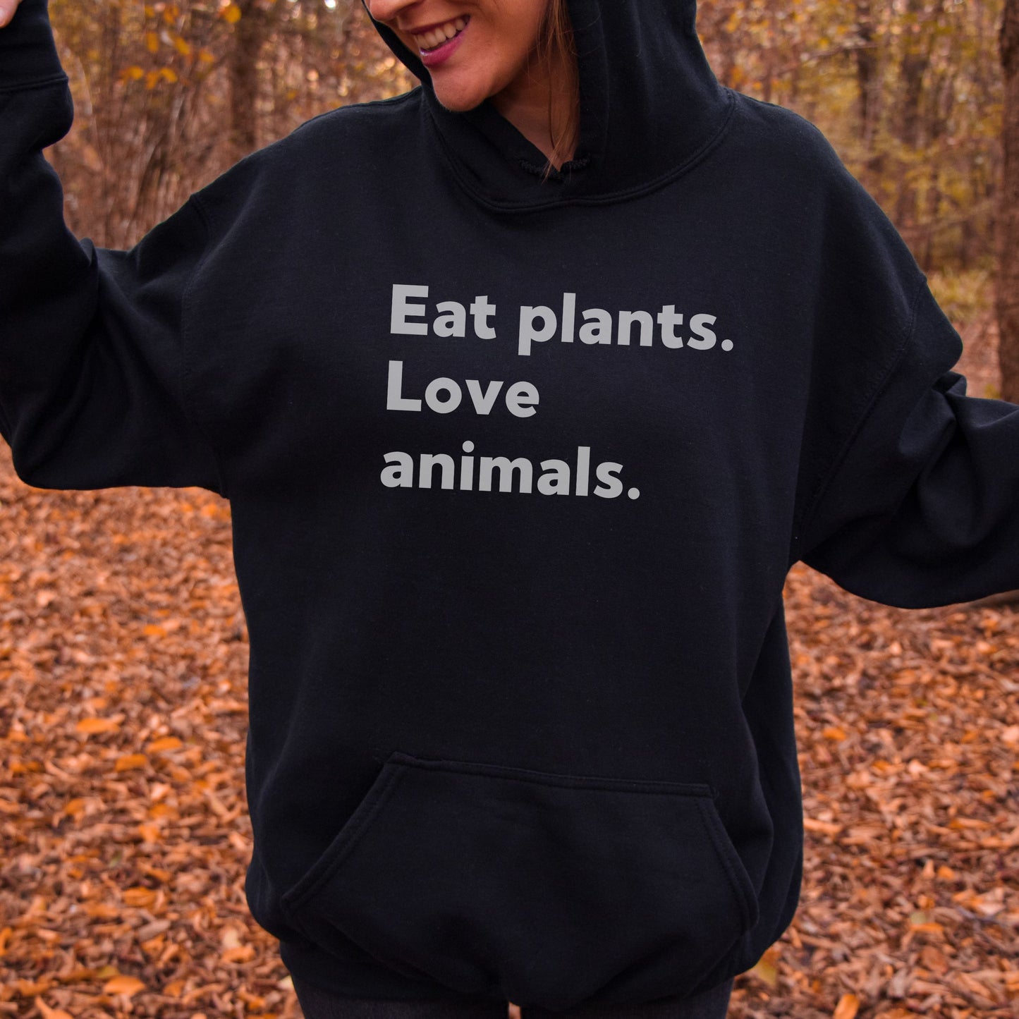 Black hoodie with the slogan 'eat plants, love animals' in white writing