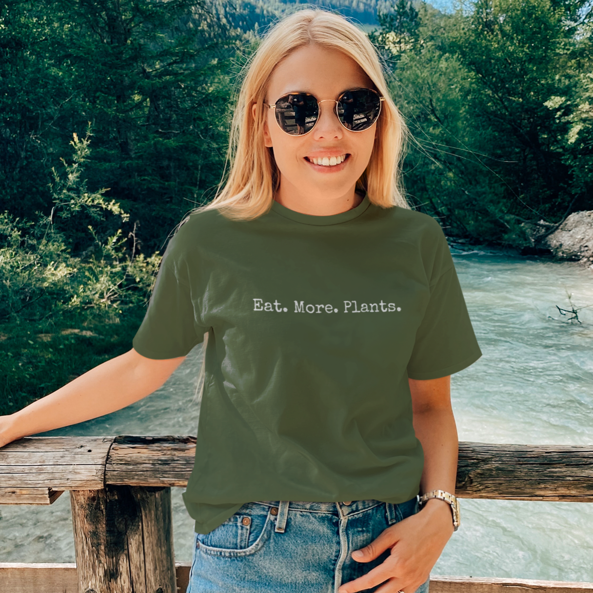 Woman wearing a khaki green minimalist vegan t-shirt with the slogan 'eat more plants'
