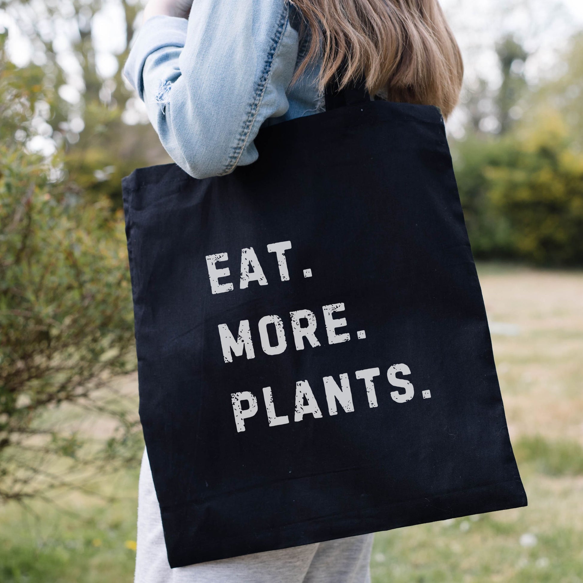 Black vegan tote bag with the slogan 'Eat More Plants'