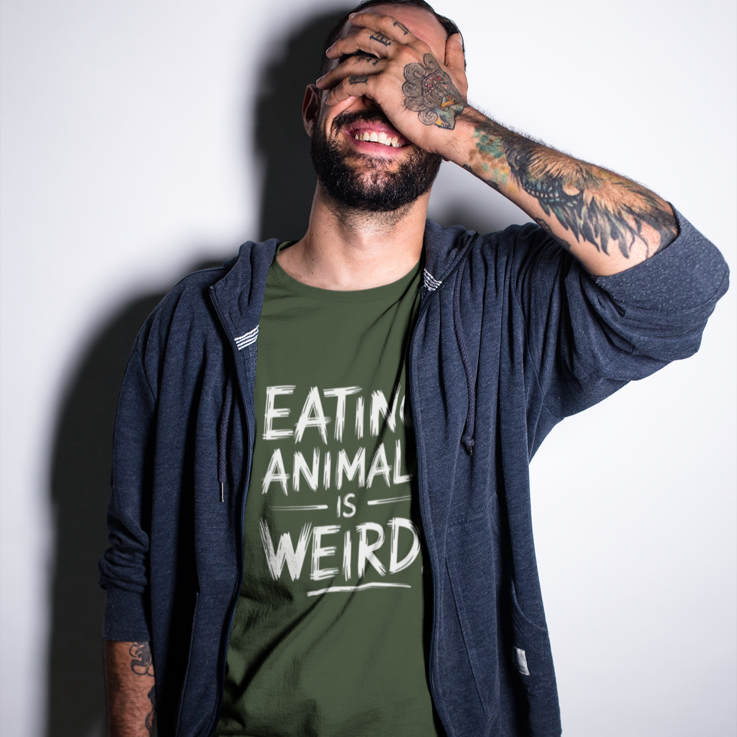 Man wearing a funny khaki green t-shirt with the slogan 'eating animals is weird'. Perfect for vegans, vegetarians and animal rights activists.
