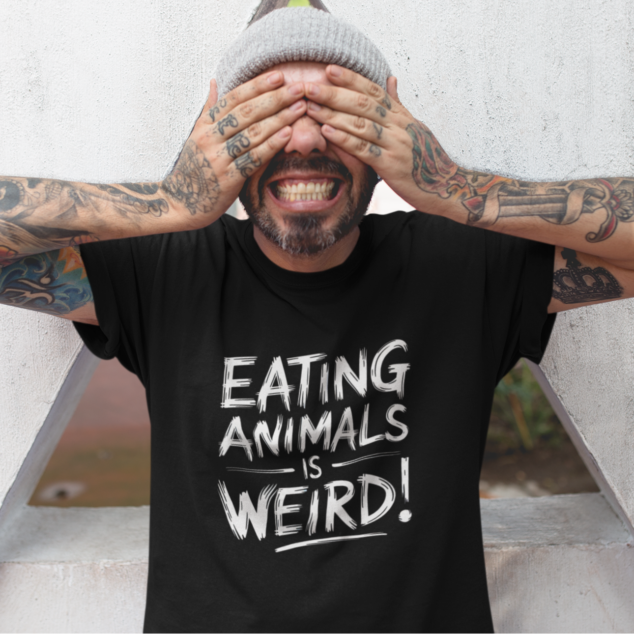Man wearing a black t-shirt with the slogan 'eating animals is weird' in a bold white font. 