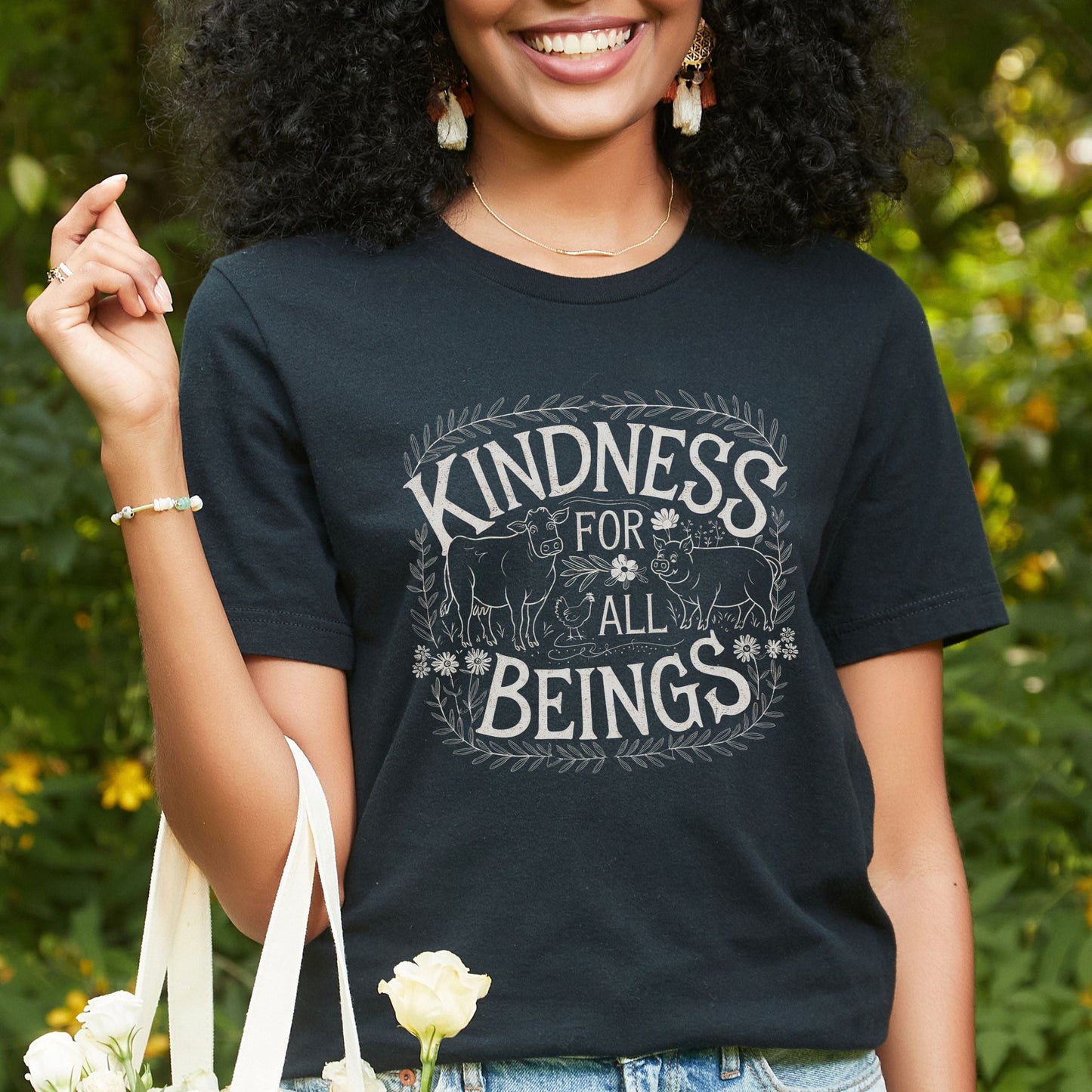 Black vegan tee shirt  featuring the slogan 'Kindness For All Beings' along with a farm animals graphic.