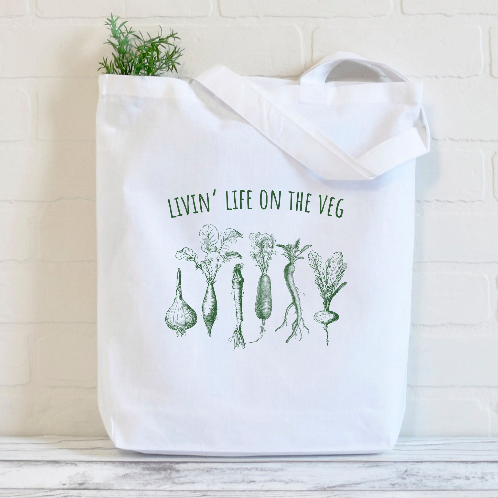 Funny white vegan tote bag with a picture of vegetables and the slogan 'Livin life on the veg'
