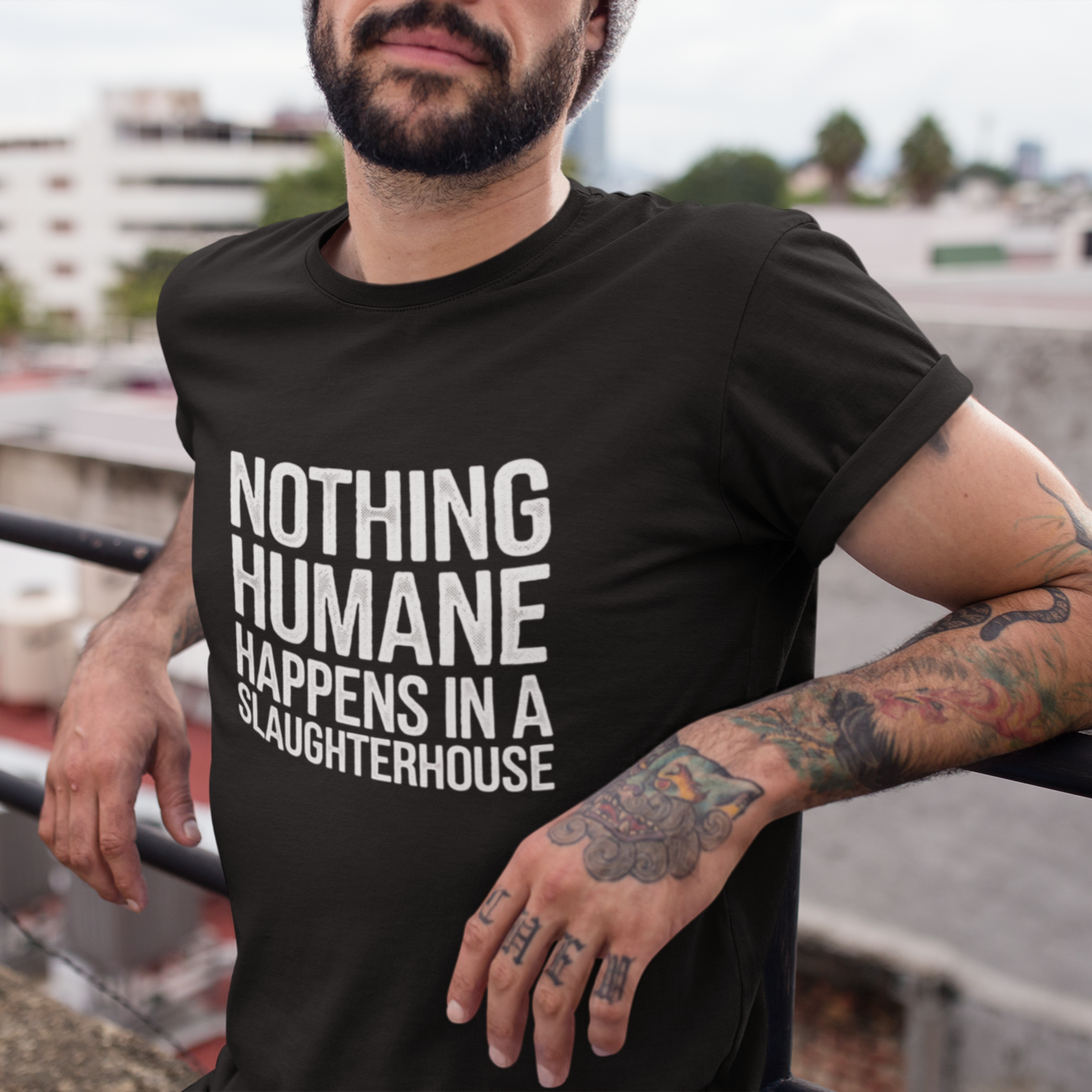 Man wearing a black t-shirt with the slogan 'nothing humane happens in a slaughterhouse' which is written in white bold writing and in a distressed font. Perfect for animal rights activists and vegans.