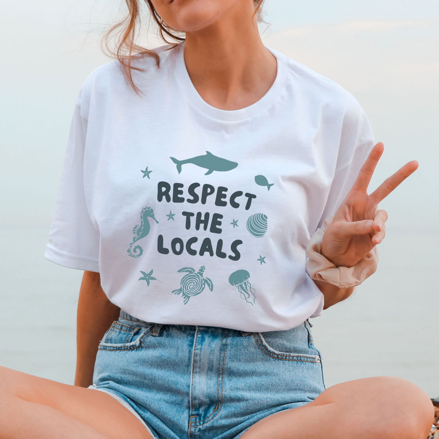 White t-shirt with the slogan 'respect the locals' and sea creatures