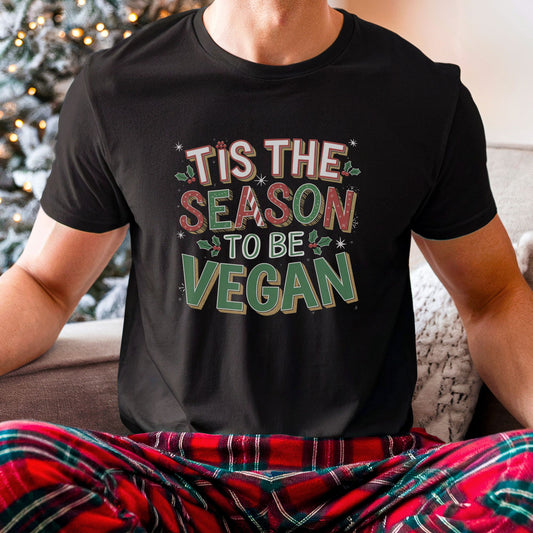 Black vegan Christmas t-shirt saying 'tis the season to be vegan' in festive colours and with holly graphics