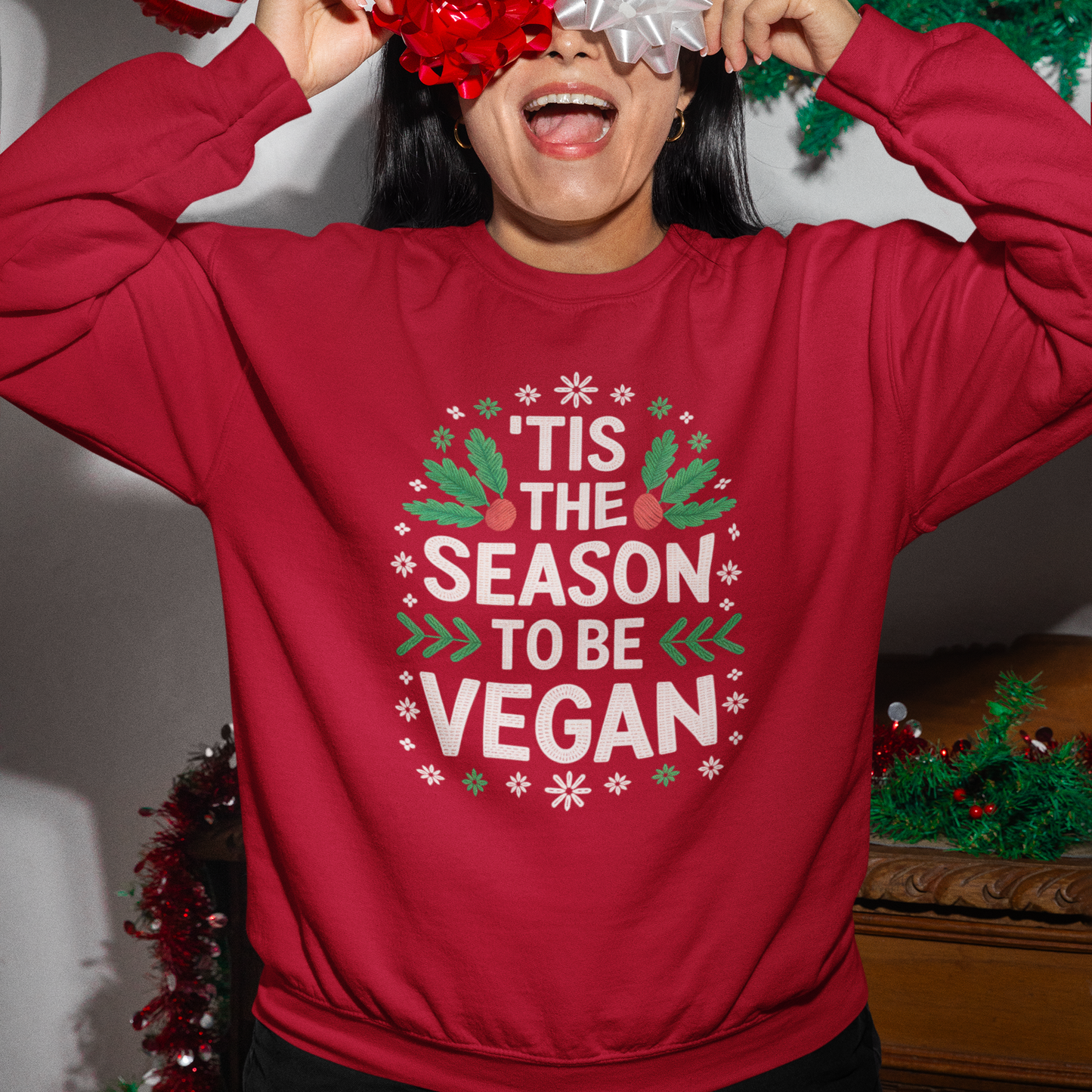 Person wearing a red 'Vegan' Christmas jumper with festive decorations.